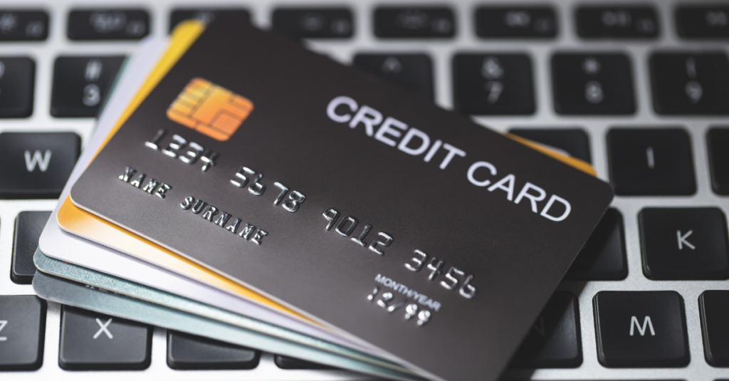 A stack of credit cards sit atop a keyboard.