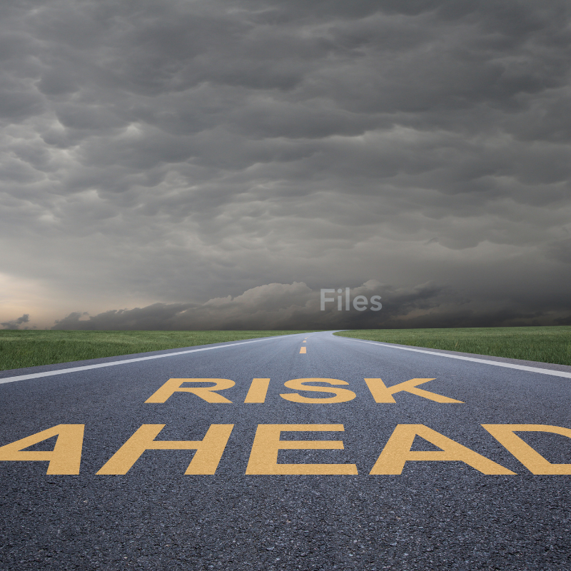 A road leads to a storm cloud. On the road reads "RISK AHEAD" and in the clouds reads "FILES."