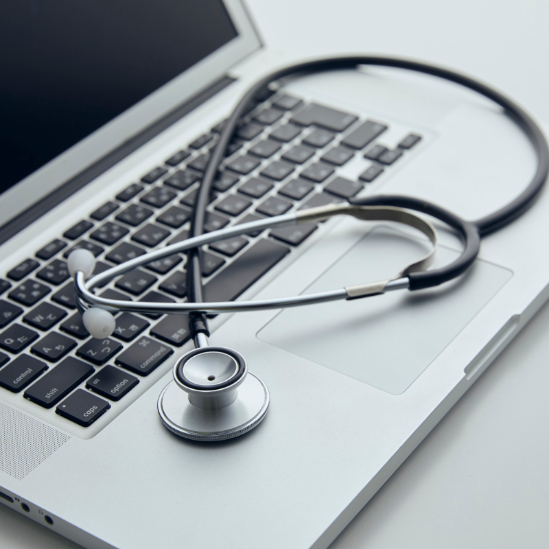A laptop with a stethoscope on it.