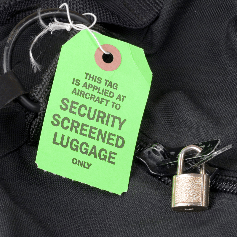 A bag with a lock on it and a tag that states it is "security screened luggage"