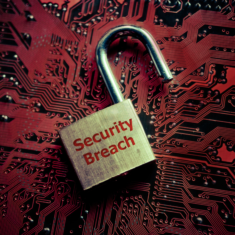 A padlock sits on top of a red computer board with the words "Security Breach" engraved on it.
