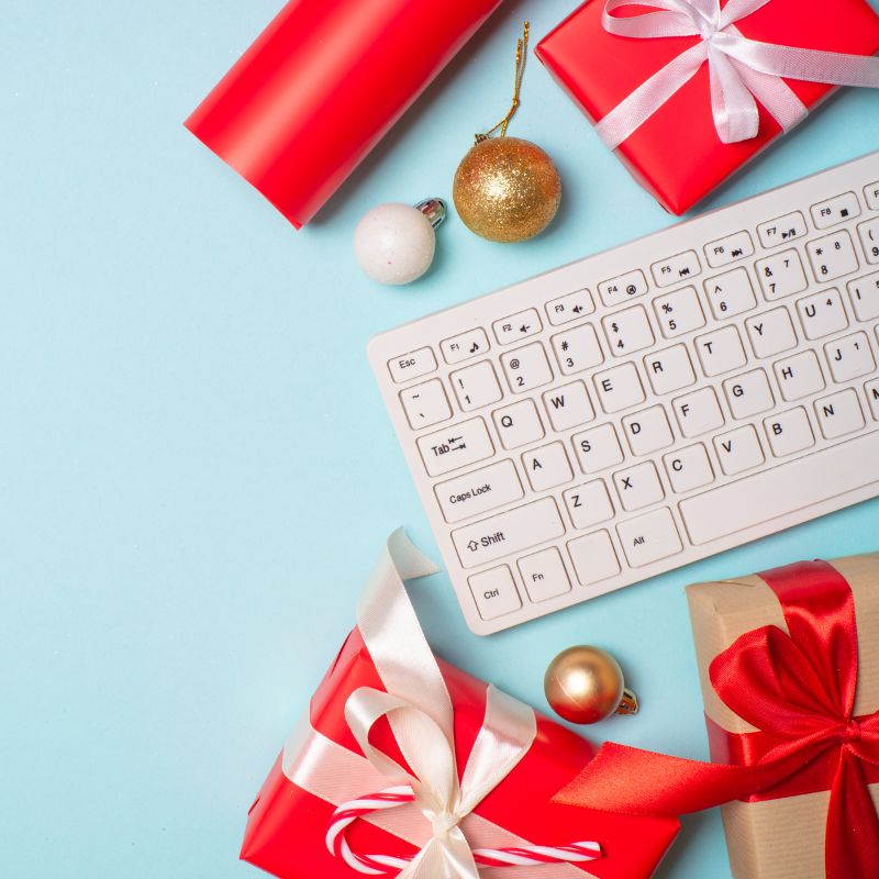 Christmas wrapping paper and gifts next to a keyboard