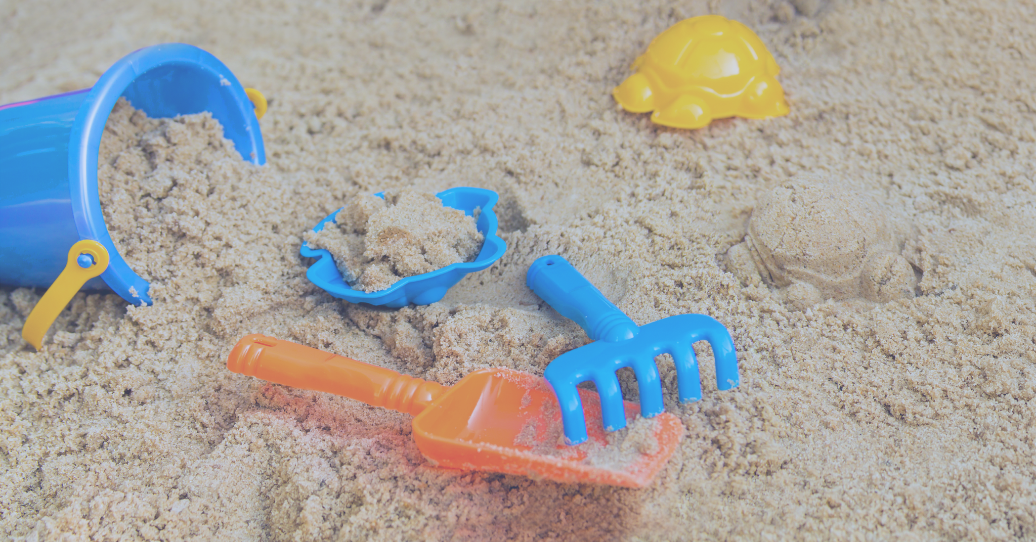 Children's bucket and other toys sitting in a sandbox - Votiro